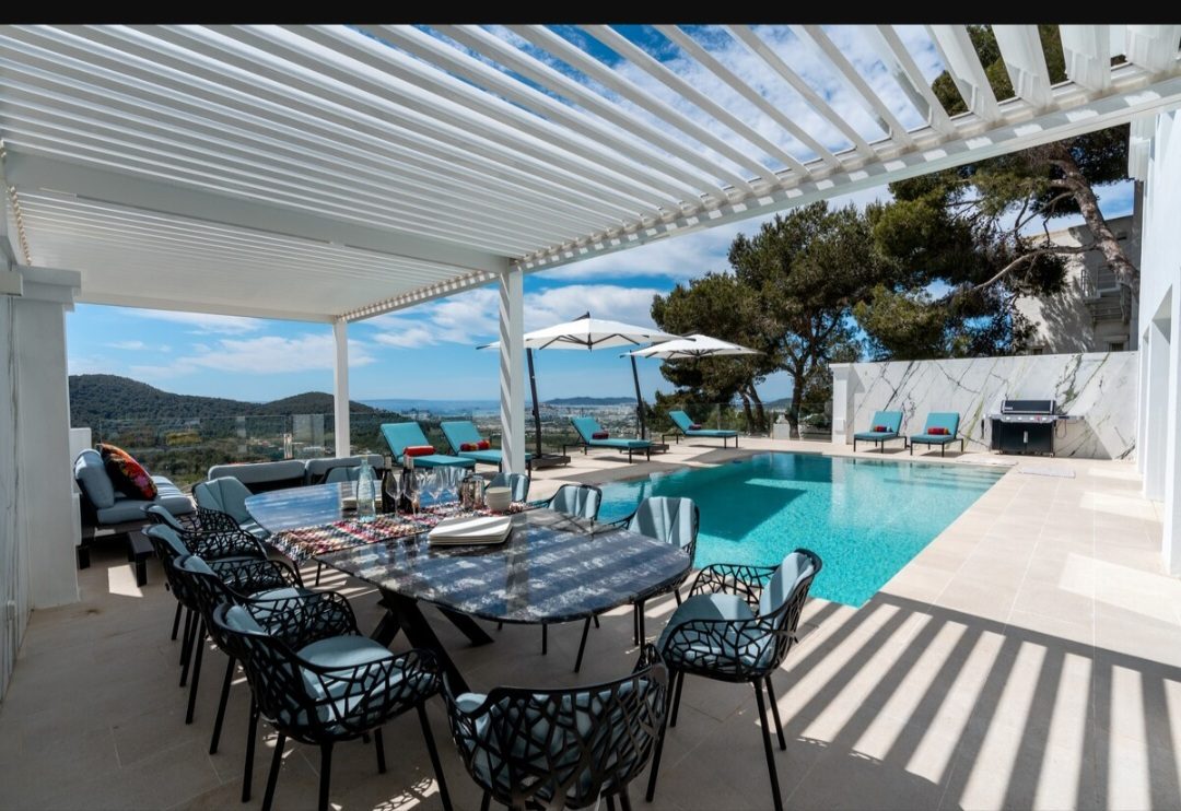 Covered pergola dining area beside the pool