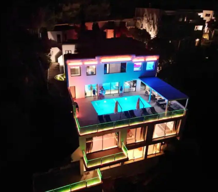 Aerial night view of the villa with pool lighting
