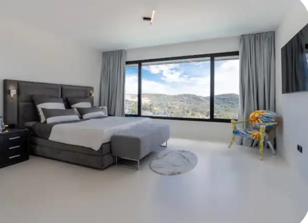 Bedroom with floor-to-ceiling hillside view