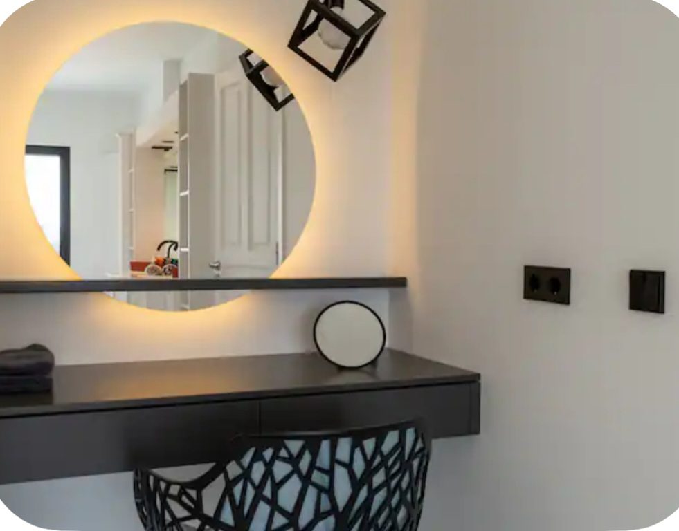 Bedroom vanity with backlit round mirror